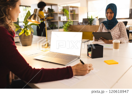 Caucasian casual businesswoman using laptop with copy space in creative office 120618947