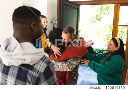 Happy diverse friends with flags welcoming home male soldier friend 120619130