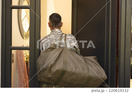 Caucasian male soldier in uniform returning home walking into house 120619132