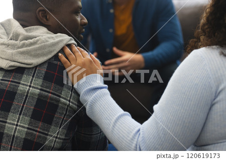 Two african american male and female friends talking and supporting each other on therapy session 120619173
