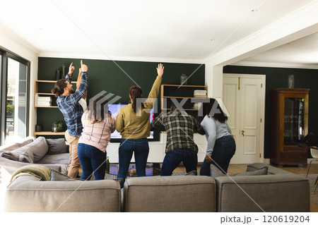 Excited diverse male and female friends watching sport on tv at home 120619204