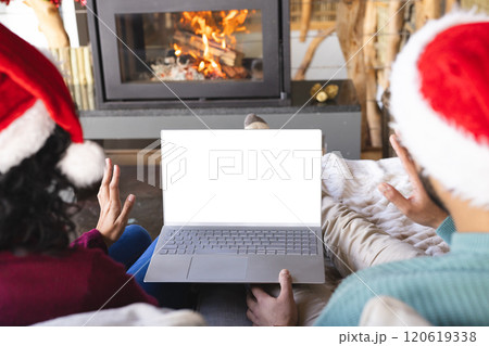 Biracial couple with santa hats on video call on laptop at christmas at home, copy space 120619338