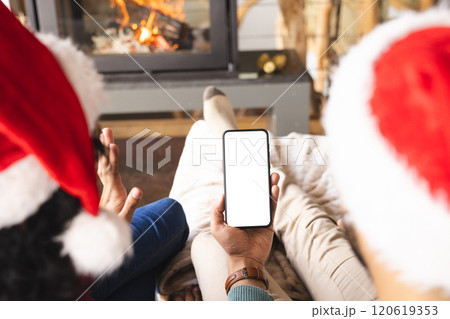 Biracial couple with santa hats having video call on smartphone at christmas at home, copy space Biracial couple with santa hats having video call on smartphone at christmas at home, copy space 120619353
