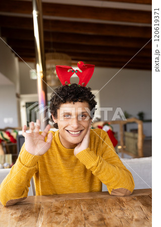 Portrait of happy biracial man wearing reindeer antlers and having video at christmas at home Portrait of happy biracial man wearing reindeer antlers and having video at christmas at home 120619371