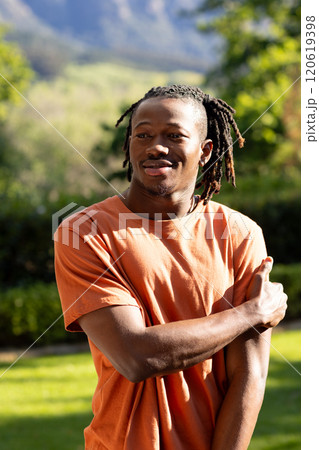Happy african american man with dreadlocks smiling in sunny garden Happy african american man with dreadlocks smiling in sunny garden 120619398