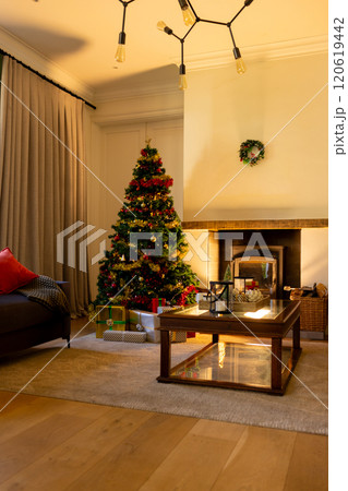 Decorated christmas tree by fireplace in homely living room, copy space Decorated christmas tree by fireplace in homely living room, copy space 120619442
