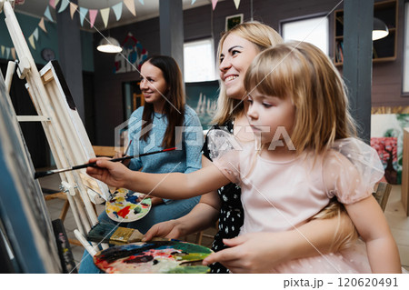 Happy moments of creativity during a family painting session in a cozy studio Happy moments of creativity during a family painting session in a cozy studio 120620491