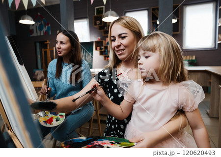 Mother and daughter enjoy creative painting activity together indoors 120620493