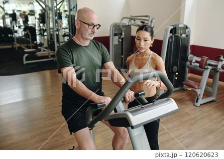 Exercising on Treadmill with Personal Trainer in Gym Exercising on Treadmill with Personal Trainer in Gym 120620623