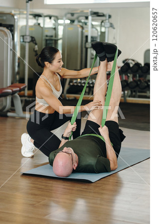 Assisting Stretching Exercise at Modern Fitness Center Assisting Stretching Exercise at Modern Fitness Center 120620657