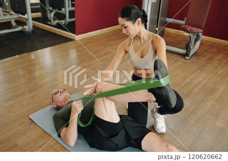 Female Trainer Assisting Client with Stretching Exercise Female Trainer Assisting Client with Stretching Exercise 120620662