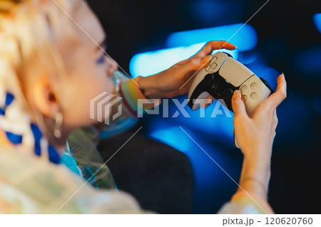 Gaming enthusiast enjoying a late-night session with a modern console 120620760