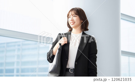 バッグを持って立つ笑顔のビジネスウーマン バッグを持って立つ笑顔のビジネスウーマン 120621035