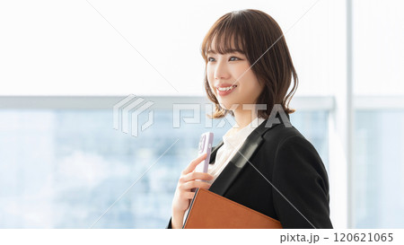スマホとバインダーを持つ笑顔の女性・ビジネスウーマン 120621065