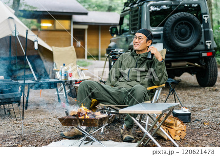 キャンプ場の林間サイトでソロキャンプする中年男性キャンパー キャンプ場の林間サイトでソロキャンプする中年男性キャンパー 120621478