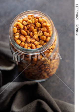 Roasted salted corn snack in jar on black table. Roasted salted corn snack in jar on black table. 120622014