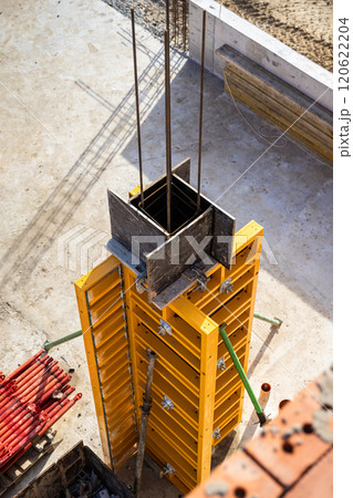 Vertical concrete formwork on construction site with reinforcement rods and framework in progress 120622204