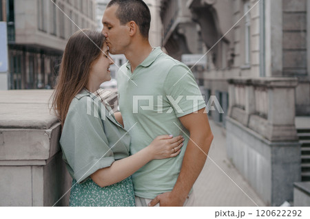 Happy couple of tourists walking embraced while sightseeing the town. Happy couple in front of palace of culture and science in Warsaw, Poland. Close up of a couple kissing. 120622292