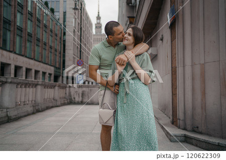 Happy couple of tourists walking embraced while sightseeing the town. Happy couple in front of palace of culture and science in Warsaw, Poland. Close up of a couple kissing. 120622309
