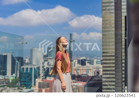 Female tourist or businesswoman standing on a skyscraper rooftop with a panoramic view of Mexico City. Travel or international business in Mexico concept Female tourist or businesswoman standing on a skyscraper rooftop with a panoramic view of Mexico City. Travel or international business in Mexico concept 120623541