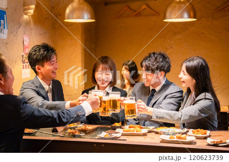居酒屋で盛大に乾杯をするビジネスパーソン 居酒屋で盛大に乾杯をするビジネスパーソン 120623739