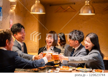 居酒屋で盛大に乾杯をするビジネスパーソン 居酒屋で盛大に乾杯をするビジネスパーソン 120623744