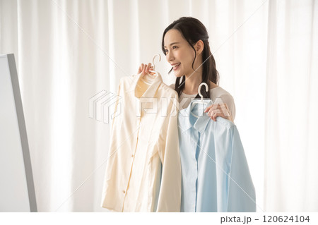 屋内で服を選ぶ若い女性 120624104