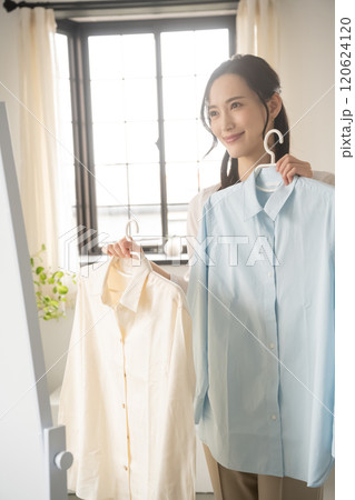 屋内で服を選ぶ若い女性 120624120