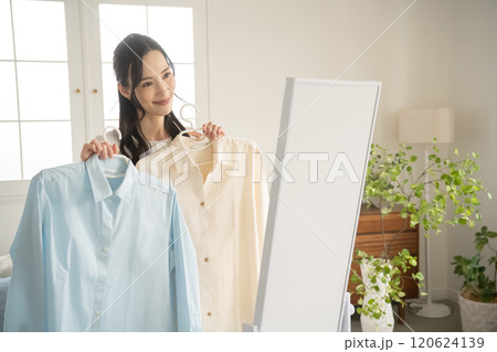 屋内で服を選ぶ若い女性 屋内で服を選ぶ若い女性 120624139