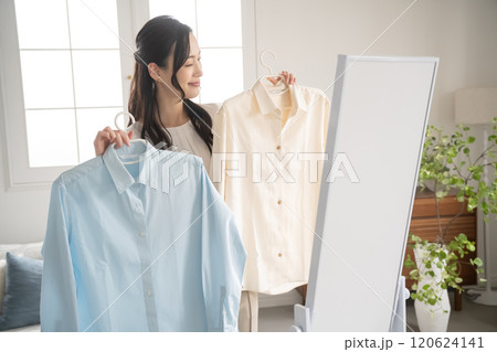 屋内で服を選ぶ若い女性 120624141