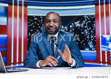 Presenter talking about daily news in newsroom, reporting live information and latest events during news anchor reportage. African american reporter announcing new night show topics. 120624972