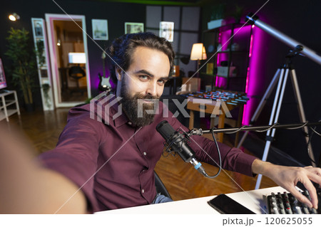 ASMR artist using quality mic and selfie camera in studio to do anti stress video, whispering tingling sounds. POV of man using professional microphone to get sleep inducing audio for zen meditation 120625055