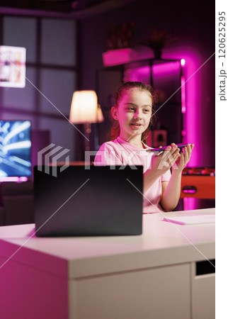 Gen Z content creator filming herself reviewing smartphone popular among children watching her online social media content. Happy little media star recording video presenting phone specs Gen Z content creator filming herself reviewing smartphone popular among children watching her online social media content. Happy little media star recording video presenting phone specs 120625295