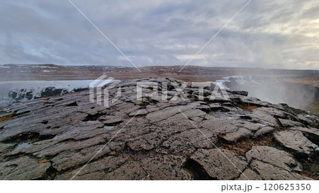 Massive river stream falling down hillside and edges in Icelandic region creating nordic Gullfoss waterfall. Fantastic wintry scenery with freezing cold water in arctic landscape running off cliffs. 120625350