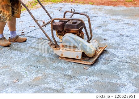 Vibratory tamping machine compacting sand during construction of pool platform Vibratory tamping machine compacting sand during construction of pool platform 120625951