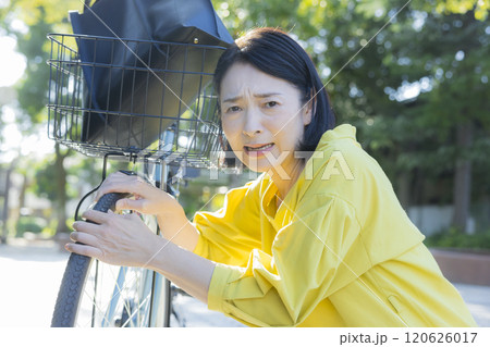 自転車が故障して困っている女性 自転車が故障して困っている女性 120626017