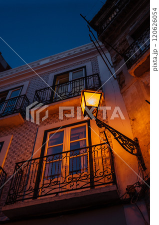 Beautiful lantern lighting up a historic balcony in a serene evening setting 120626054