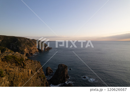 Scenic coastal view during sunset at a rocky shoreline with gentle waves Scenic coastal view during sunset at a rocky shoreline with gentle waves 120626087