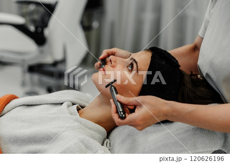 Client receiving facial treatment at a skincare studio on a relaxing day 120626196