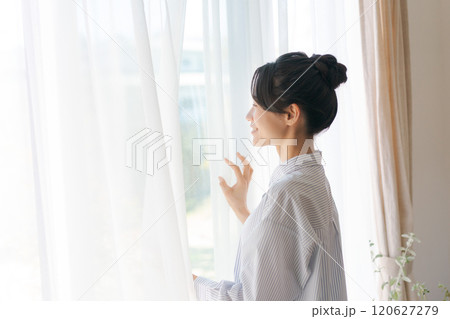 カーテンを開ける女性 120627279