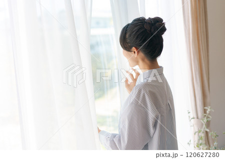 カーテンを開ける女性 120627280