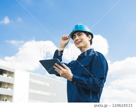 建物の前でタブレットPCを使う男性作業員 120628515