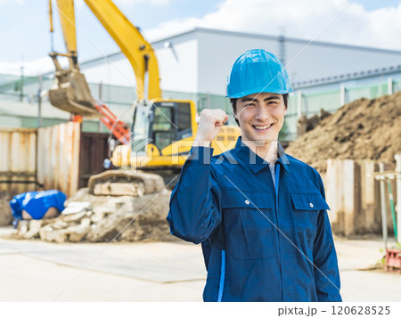 工事現場の前でガッツポーズする男性作業員 工事現場の前でガッツポーズする男性作業員 120628525