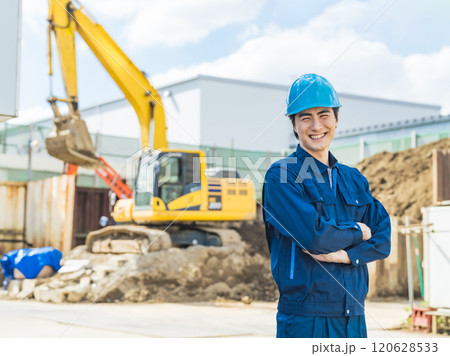 工事現場の前に笑顔で立つ男性作業員 120628533