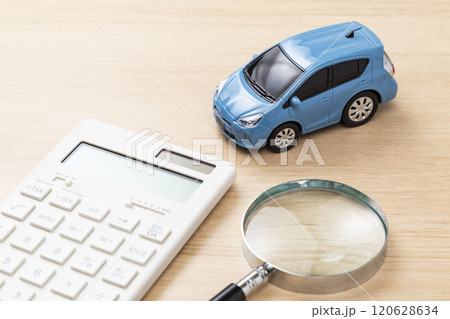テーブルに置かれた自動車と電卓と虫メガネ テーブルに置かれた自動車と電卓と虫メガネ 120628634