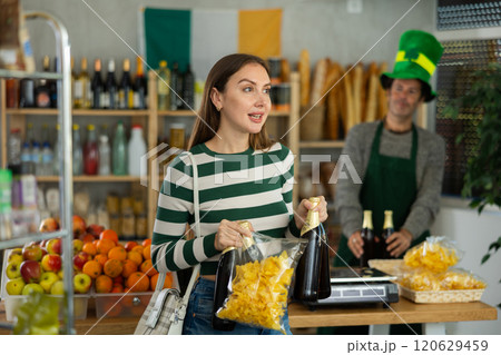 Girl happy with purchase of Irish beer or traditional ale during St Patrick Day celebrations 120629459