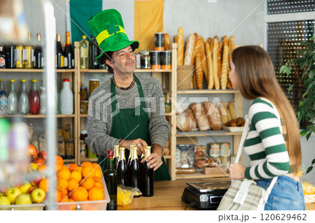 Friendly male salesman in St. Patrick hat offers to buy girl traditional Irish ale Friendly male salesman in St. Patrick hat offers to buy girl traditional Irish ale 120629462