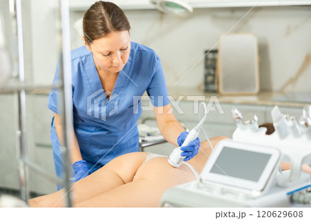 Cosmetologist makes cryo therapy lifting with skin rejuvenation and smoothing for woman use electric device equipment in spa center. Body care Cosmetologist makes cryo therapy lifting with skin rejuvenation and smoothing for woman use electric device equipment in spa center. Body care 120629608