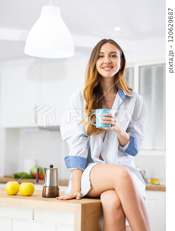 Happy young girl in shirt with cup of coffee 120629687