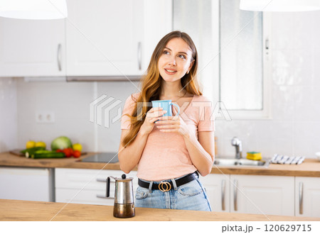 Portrait of attractive woman posing near table with cup of coffee 120629715